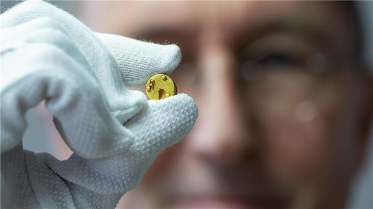 Römisches Mini-Dosenschloss aus Gold gibt Rätsel auf Der Chefarchäologe des LWL, Michael Rind, hält das Minischloss zwischen Daumen und Zeigefinger.