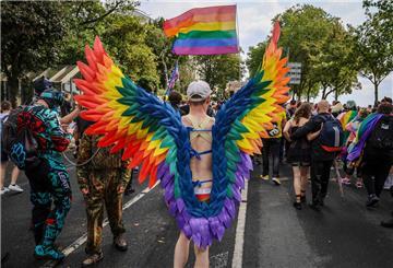 Ein Teilnehmer des Christopher Street Day (CSD) trägt regenbogenfarbene Flügel.