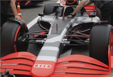  Teammitglieder schieben den neuen Rennwagen von Audi 