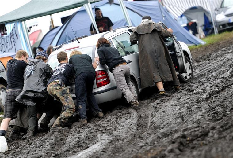 Stau und Schlammschlacht: Wacken-Fans brauchen viel Geduld Festivalbesucher schieben auf dem Campingplatz des Wacken Open Air Festivals (Kreis Steinburg) ein Auto aus dem Schlamm