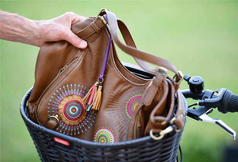 Bremen: Kinder beobachten Taschendieb und stellen ihn Eine Hand greift nach einer in einem Fahrradkorb liegenden Handtasche