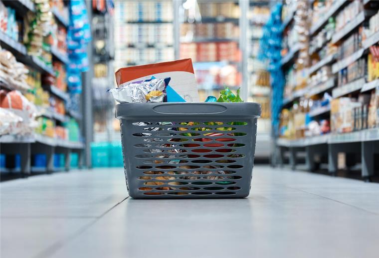 Ein Einkaufskorb steht in einem Supermarkt auf dem Boden. Der Einkauf im Supermarkt oder Gartencenter hat sich verändert. Seit 2025 gilt eine neue Pflicht, die alle Kunden betrifft.