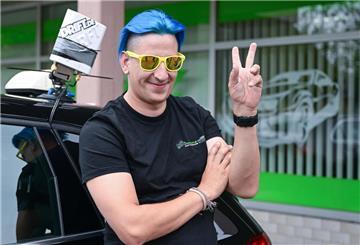 Der Fahrlehrer Fabian Schittenhelm steht an einem Schulfahrzeug gelehnt.