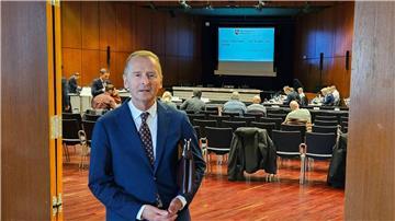 Der frühere Volkswagenchef Herbert Diess steht vor einem Saal in der Braunschweiger Stadthalle.