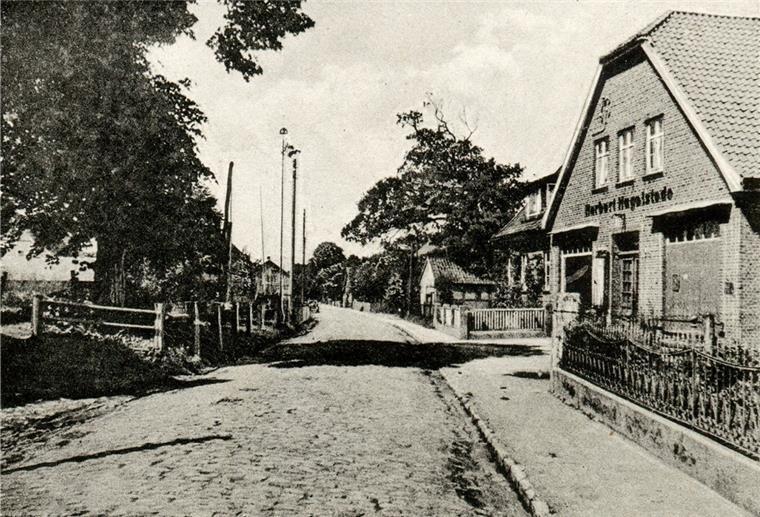 Kopfsteinpflasterstraße mit Geschäftshaus auf der rechten Seite