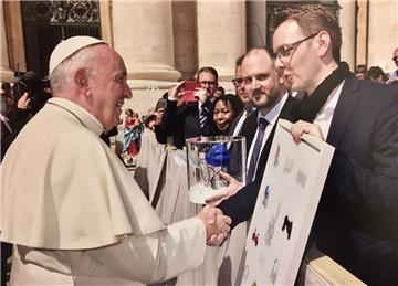 Der große Augenblick auf dem Petersplatz in Rom: Sascha Dörger aus Langen (rechts) überreicht Papst Franziskus seine grafische Interpretation der Zehn Gebote.