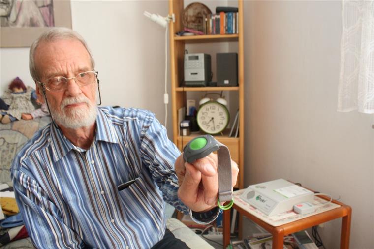 Der Hausnotruf: Helmut Weichert zeigt das Armband mit dem grünen Schalter, das wegen des Router-Defekts nicht funktionierte.