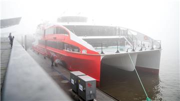 Der Helgoland-Katamaran „Halunder Jet“ legt am Morgen im dichten Nebel im Hafen auf der Elbe.
