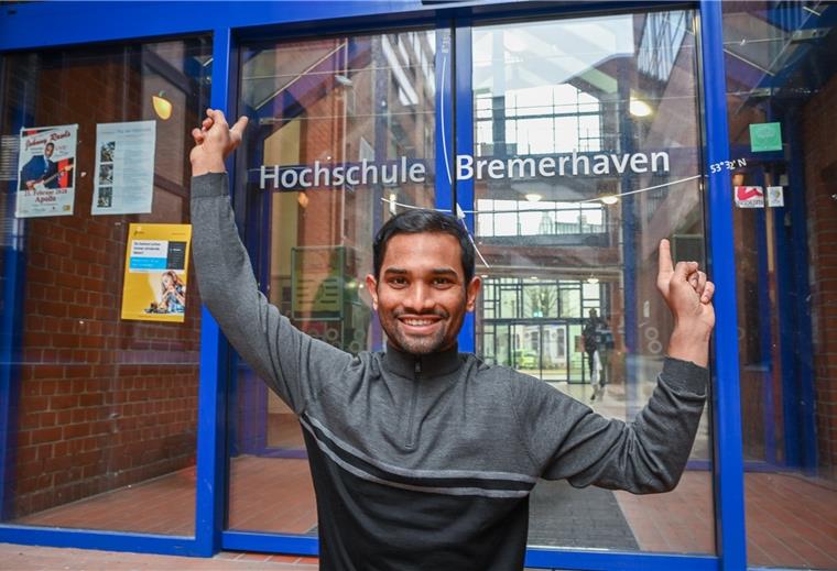 Der Inder Kesava Saripalli zeigt auf seine neuen Koordinaten an der Hochschultür. Er ist fürs Studium nach Bremerhven gekommen.