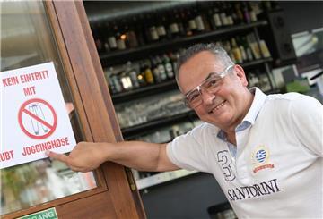 Der Inhaber des Pforzheimer „Art Café“ Lambros Petrou zeigt ein Schild mit der Aufschrift „Kein Eintritt mit Jogginghose“. Er hat genug von Jogginghosen und ihren Tragenden.