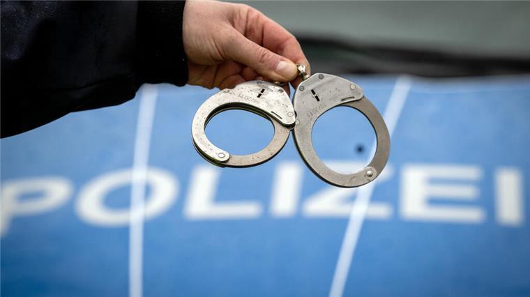 15-Jähriger Bremerhavener droht mit Anschlag - und löst Großeinsatz aus Handschellen und ein Polizeifahrzeug
