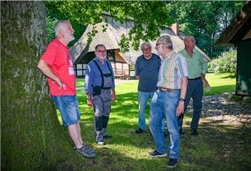 Vier Männer stehen auf einem Hof.
