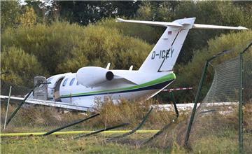 Der Kleinjet von Dirk Ahlers liegt nach der Landung auf dem Flugplatz Egelsbach hinter dem Maschendrahtzaun in einem Feld.

