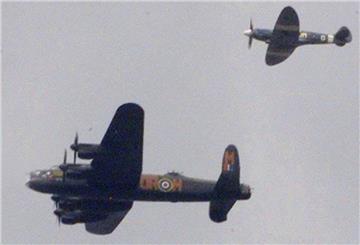 Ein Lancaster-Bomber wird von einem Jagdflugzeug begleitet.