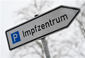 Ein Wegweiser zeigt zum Parkplatz für ein Impfzentrum.