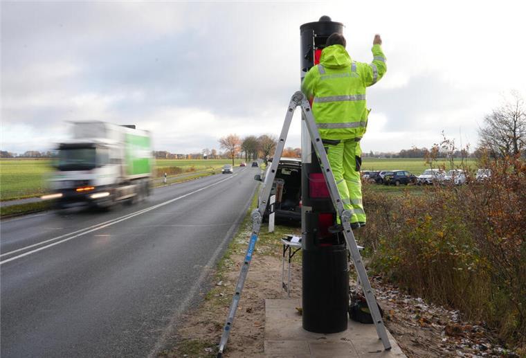 Ein Mann baut einen Blitzer an der L119 bei Neuenwalde auf.