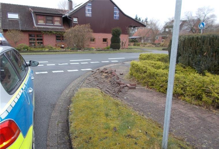 Polizeiwagen steht neben beschädigtem Gehweg. 