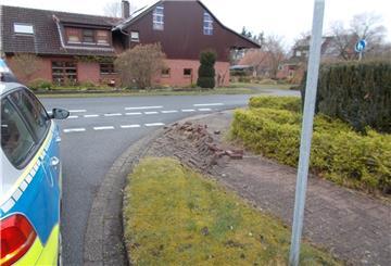 Polizeiwagen steht neben beschädigtem Gehweg. 