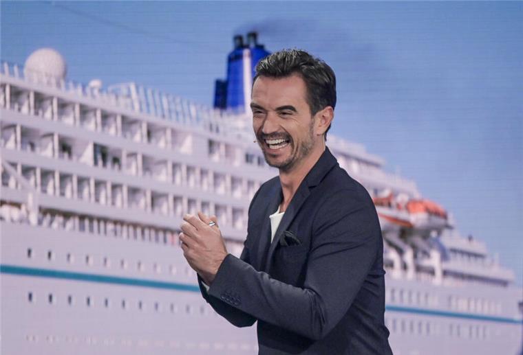 Florian Silbereisen schaut das „Traumschiff“ an Weihnachten allein Der Moderator Florian Silbereisen steht vor einem Bild des Traumschiffs.