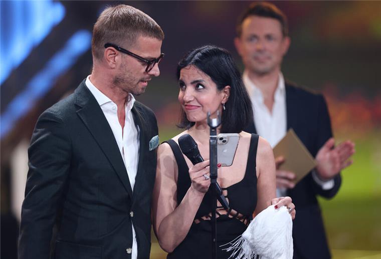 Der Moderator Joko Winterscheidt steht neben der iranischen Frauenrechtsaktivistin Azam Jangravi, nachdem er den Preis Beste Doku-Serie für seine Prime Video-Sendung "Joko Winterscheidt Presents: The World’s Most Dangerous Show" bekommen hat.