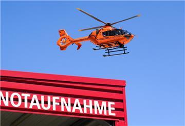 Ein Rettungshubschrauber der Luftrettung fliegt über einer Notaufnahme.