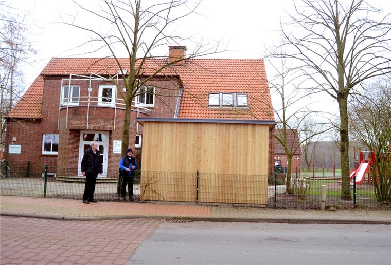 Der neue Schuppen vor dem Kindergarten in Stinstedt bietet Platz für Spielzeug und Geräte. Das Gebäude passe dort aber optisch überhaupt nicht hin, meint Harald Wrede (links), der auch Mitglied im Gemeinderat ist.