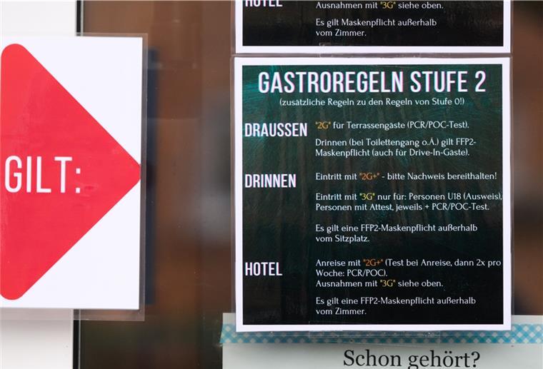 Regeln für die Gastronomie während der Corona-Pandemie hängen am Eingang eines Restaurants