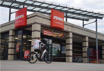Ein Radfahrer fährt an einem Supermarkt vorbei