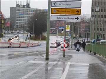 Der Platz für einen gemeinsamen Geh- und Radweg auf der Kennedybrücke in Bremerhaven reicht nach heutigem Stand nicht mehr aus. Ein Schild mitten im aufgezeichneten Radweg und fest eingebaute Lampenmasten gefährden Fahrradfahrer.