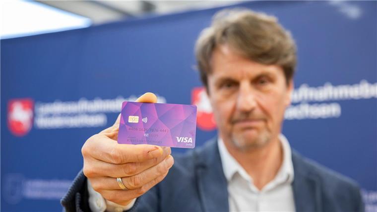 Der Präsident der Landesaufnahmebehörde präsentiert eine der ersten Bezahlkarten für Geflüchtete.