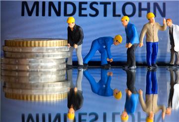 Miniaturfiguren stehen am 26.02.2015 in Schwerin (Mecklenburg-Vorpommern) vor einem Display mit der Anzeige «Mindestlohn» (gestelltes Foto).