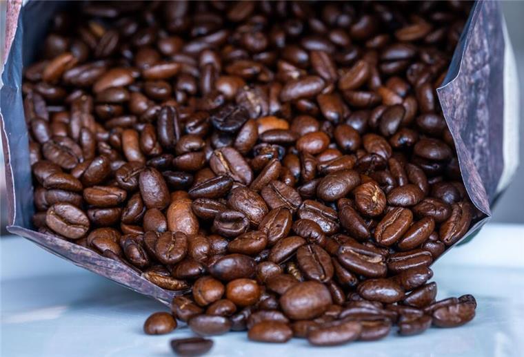 Preisschock: Kaffee wird teurer - Aldi und Co. ziehen die Preise an Geröstete Kaffeebohnen liegen vor einer Tüte.