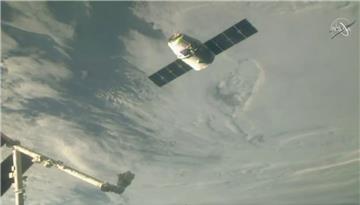 Der  Raumfrachter Dragon nähert sich einem Roboterarm zum Andocken an die Internationale Raumstation ISS. Der Frachter ist unter anderem mit einem Weihnachtsmenü beladen. 