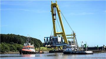 Der Schwimmkran „Cormorant“ transportiert Brückenteile über die Ems zur Brückenbaustelle.