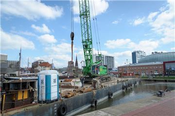 Der Seilbagger hievt die Reste der maroden Steganlage auf den Trägerponton im Neuen Hafen in Bremerhaven.
