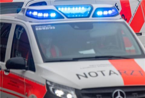Ein Notarztwagen und Rettungswagen fahren durch die Stadt.