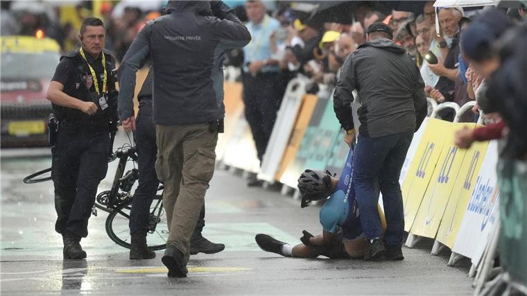 Mit Rad im Tour-Zielbereich: Sicherheitskräfte stoppen Mann Der Störer liegt auf dem Asphalt, nachdem er von Sicherheitskräften aufgehalten wurde.