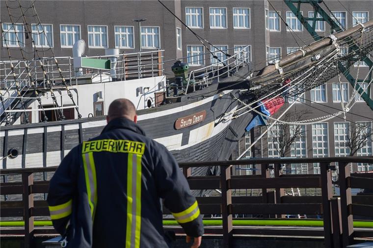 Der Tag nach dem Brand: Ein Feuerwehrmann steht vor dem am Alten Hafen liegenden Traditionssegler "Seute Deern". Sechs Monate später ist die Untersuchung abgeschlossen.  