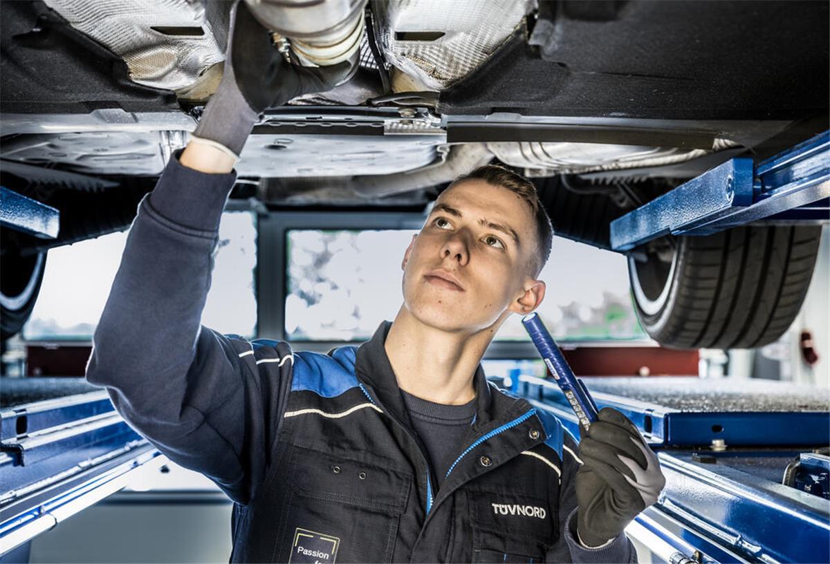 TÜV-Hammer! Diese neue Regel kostet Autofahrer Hunderte Euro mehr im Jahr Ein Mitarbeiter vom TÜV repariert ein Auto. Der TÜV nimmt ältere Autos aufs Korn. Für sie sollen bald andere Regeln gelten.