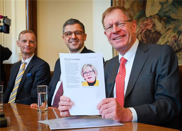 Der verwaltende Vorsteher des Hauses Seefahrt, Matthias Claussen, mit dem Porträt von Janina Marahrens-Hashagen. Links der erste Schaffer 2020, Thomas Kriwat, mit Bülent Uzuner, dem zweiten Schaffer. 