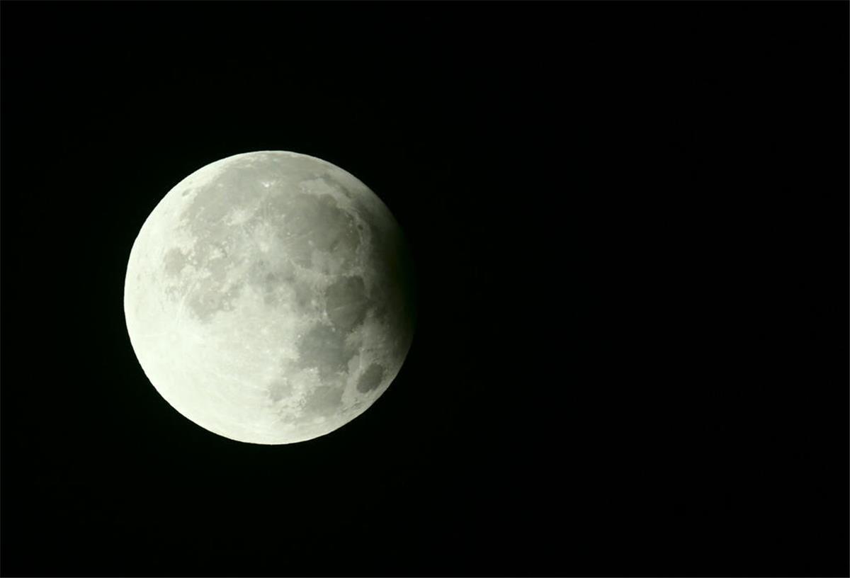 Der volle Mond steht teilweise im Schatten der Erde. Man sieht am rechten Rand die partielle Mondfinsternis. Der Erntemond steht der Erde sehr nahe und wird deswegen auch Supermond genannt.