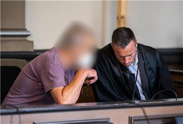 Ein wegen zweifachen Mordes und versuchten Mordes angeklagter Mann sitzt kurz vor Prozessfortsetzung in einem Gerichtssaal des Landgerichts Verden und unterhält sich mit seinem Pflichtverteidiger.
