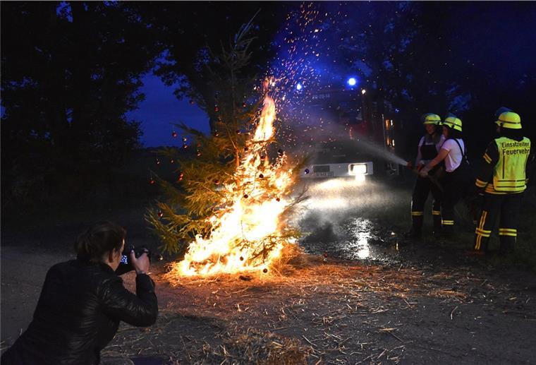 Die Frauen der Freiwilligen Feuerwehr löschen einen Tannenbaum.