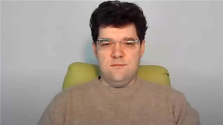 Ein Mann sitzt auf einem Stuhl.