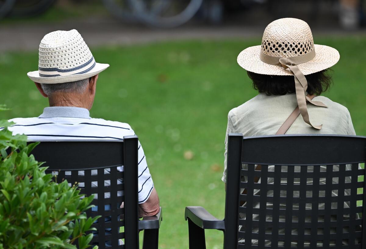 Symbolbild für Rentner erhalten 2025 hohe Nachzahlungen: Ein älteres Paar verfolgt im Kurpark das Konzert eines Schulorchesters.