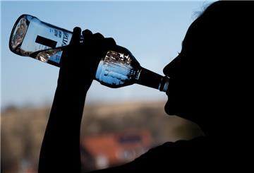 Ein Mädchen trinkt aus einer Flasche Wodka.