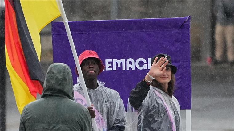 Olympia-Eröffnungsfeier als knallbuntes Spektakel im Regen Deutschlands Fahnenträger im Regen: Dennis Schröder und Anna-Maria Wagner.