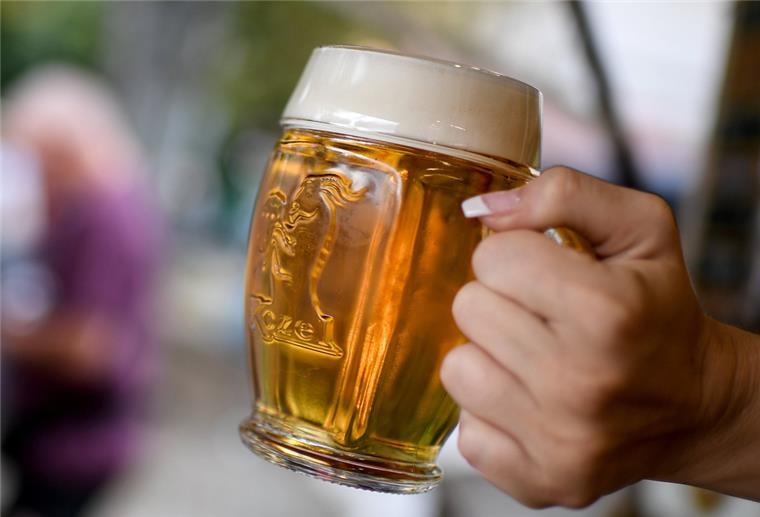 Eine junge Frau schenkt an einem Stand Bier aus.