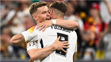 Zwei Fußball-Spieler aus Deutschland umarmen sich auf dem Platz.