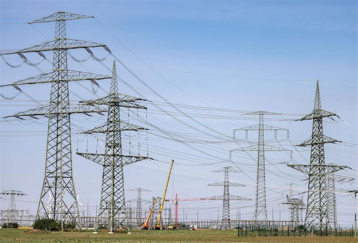 Stromnetz am Limit: Darum steht Deutschland bei KI-Plänen vor dem Kollaps Monteure errichten einen Strommast in der Nähe des Kraftwerks Schkopau.